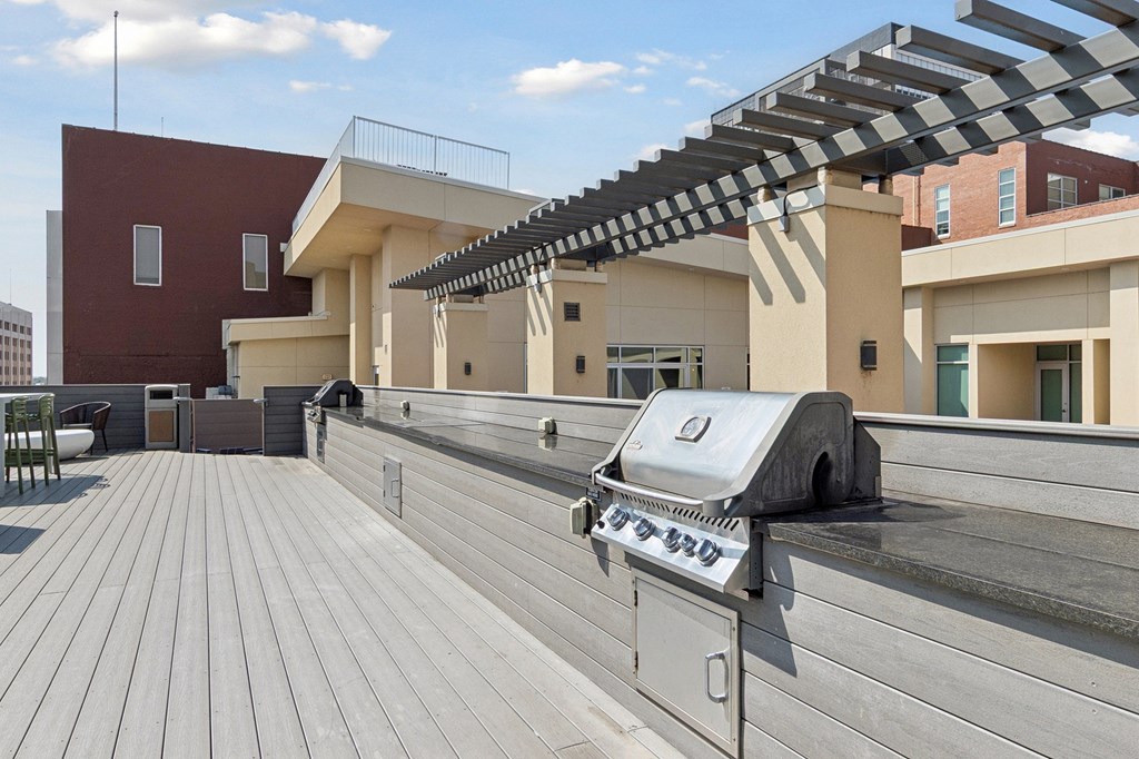 A grill is on a wooden deck.