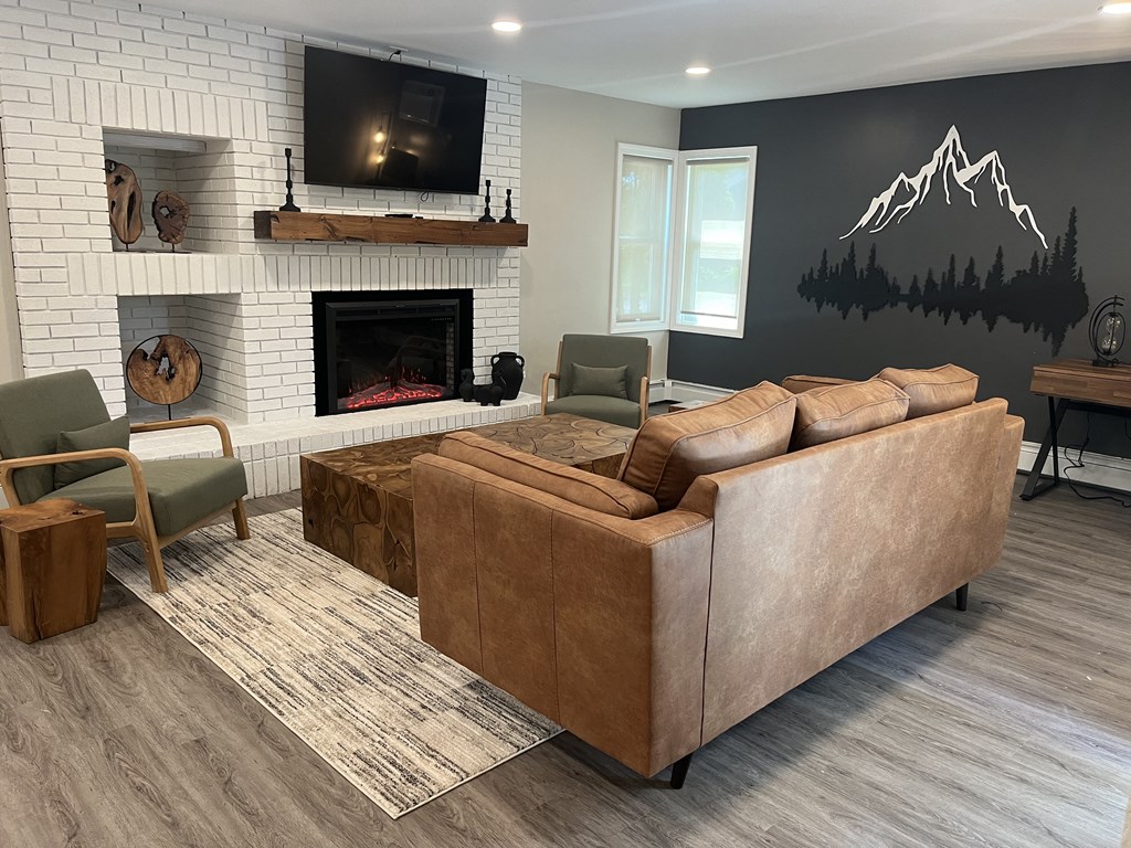 Club house with a white brick fireplace and a couch and a TV
