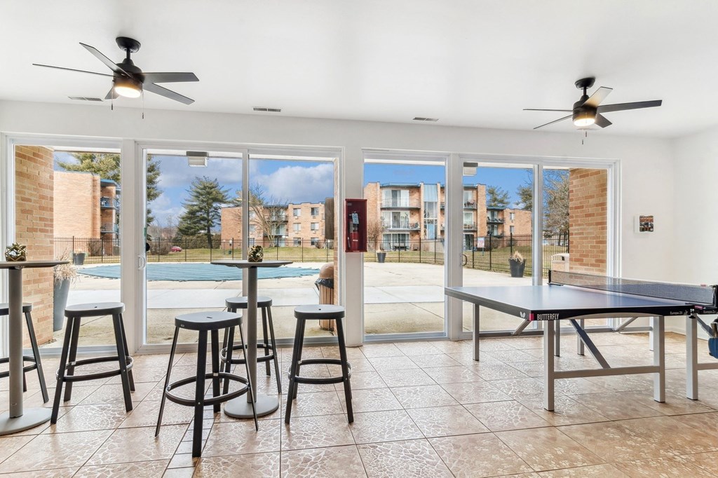 Open room with a pool and tables and ceiling fans at The Reserve on Washington, Illinois