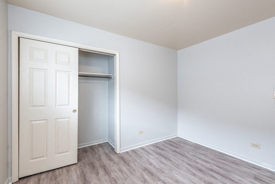 A white door is open to a room with a grey floor.