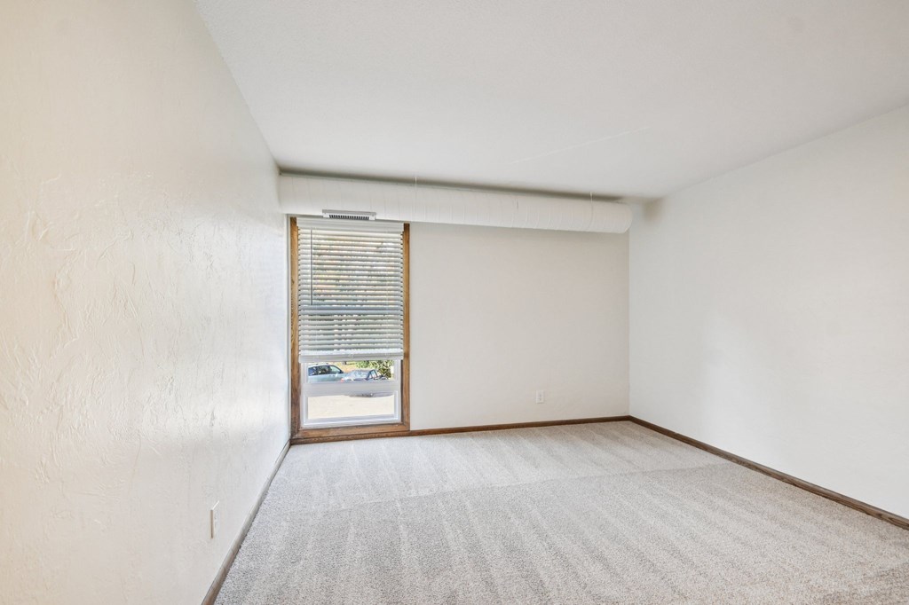 A room with a carpeted floor and a sliding glass door.