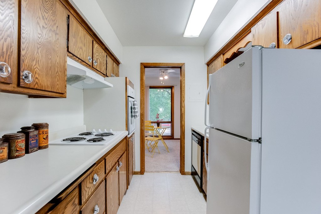 A kitchen with wooden cabinets and a white refrigerator.
