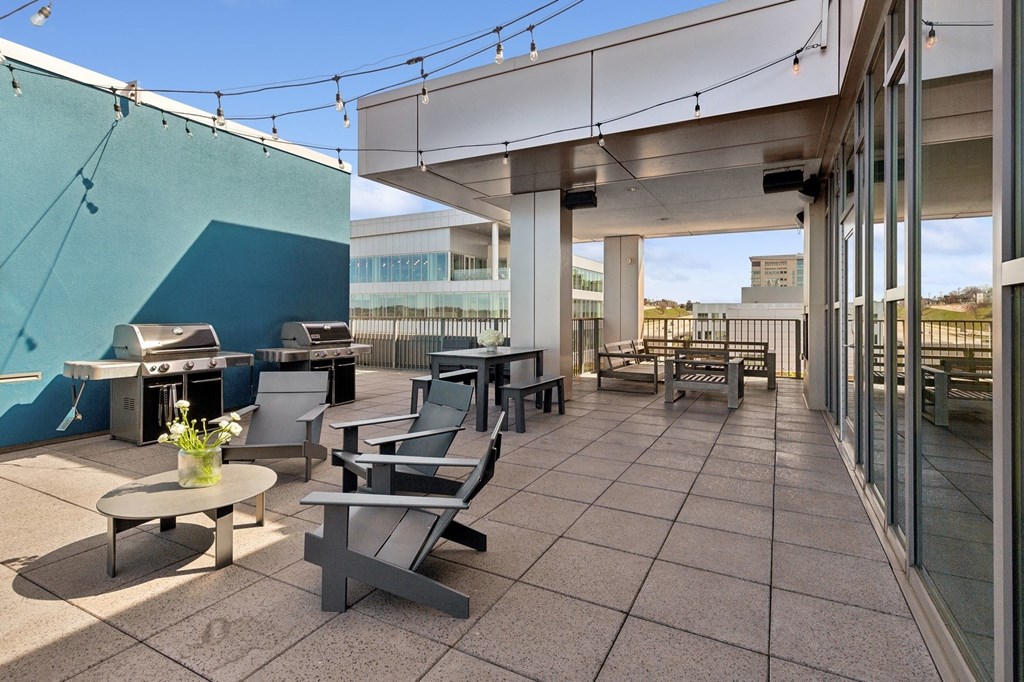 a patio with tables and chairs and a grill on the side of a building at The Rowe, Michigan