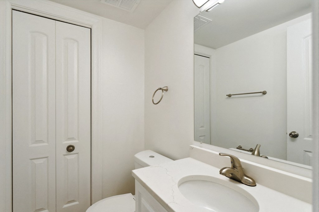 a bathroom with a white sink and toilet next to a white door at The Hinsdale, Hinsdale, Illinois