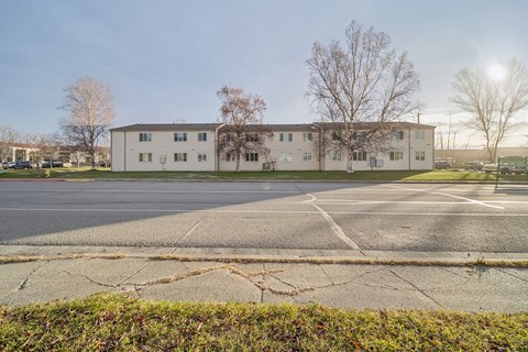 A large white building with a parking lot in front.