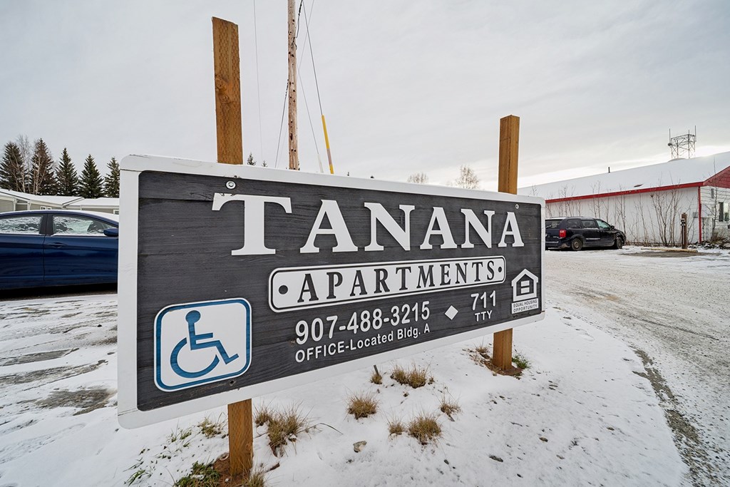Tanana Apartments sign with a phone number and a wheelchair symbol.