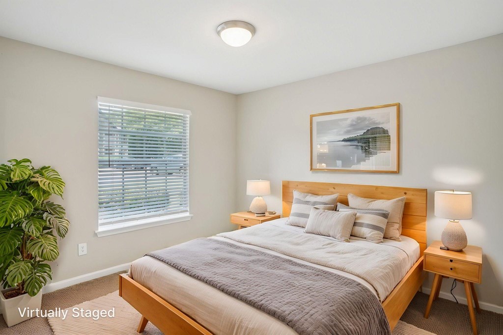 A bedroom with a bed, nightstand, and lamp.