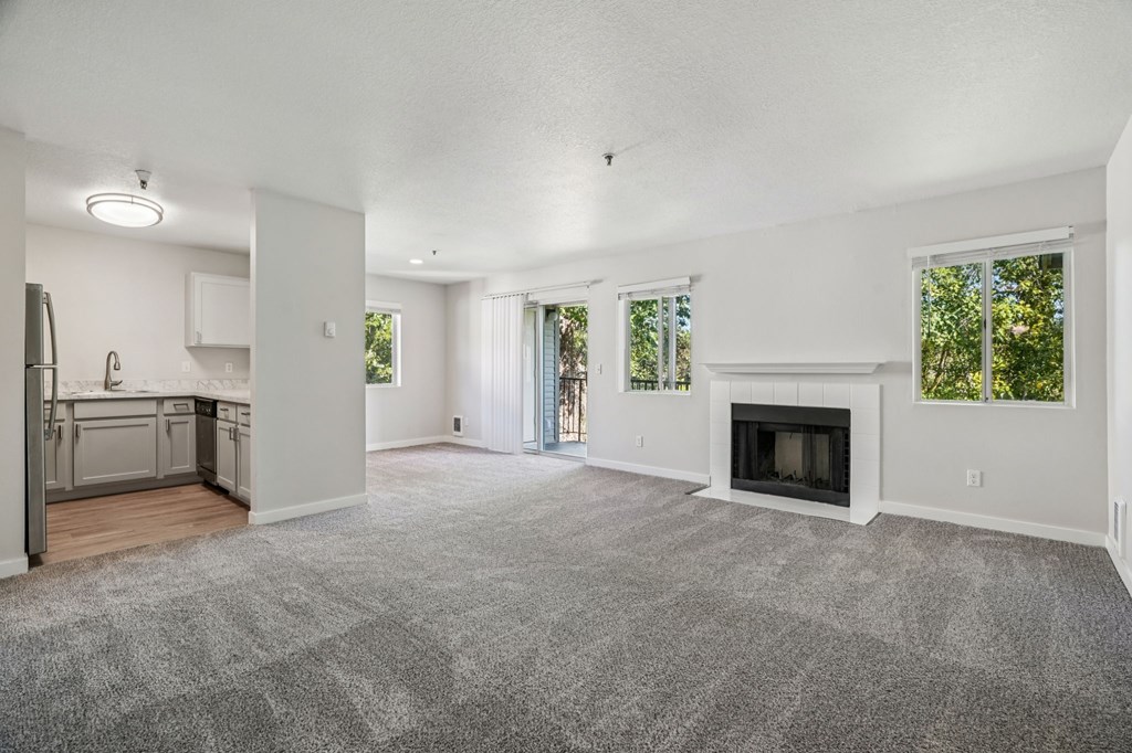 A spacious living room with a fireplace and sliding glass doors.