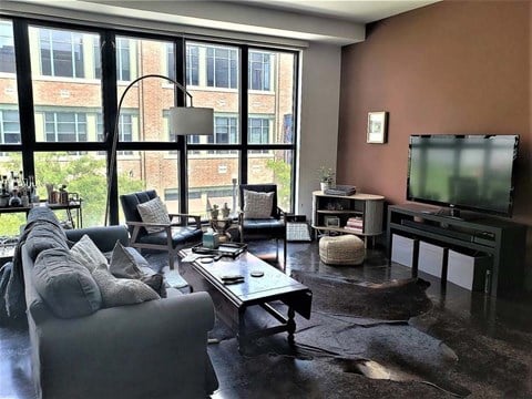 a living room filled with furniture and a flat screen tv at Flats at Southside, Pittsburgh, PA 