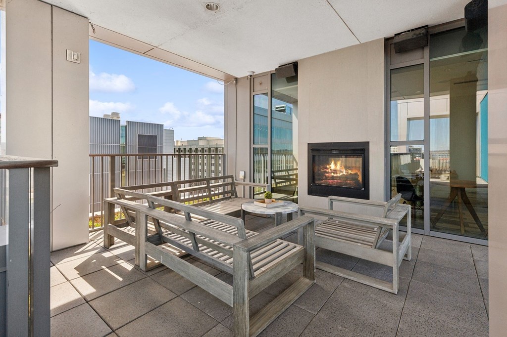 a living room with a fireplace and wooden benches at The Rowe, Grand Rapids, MI