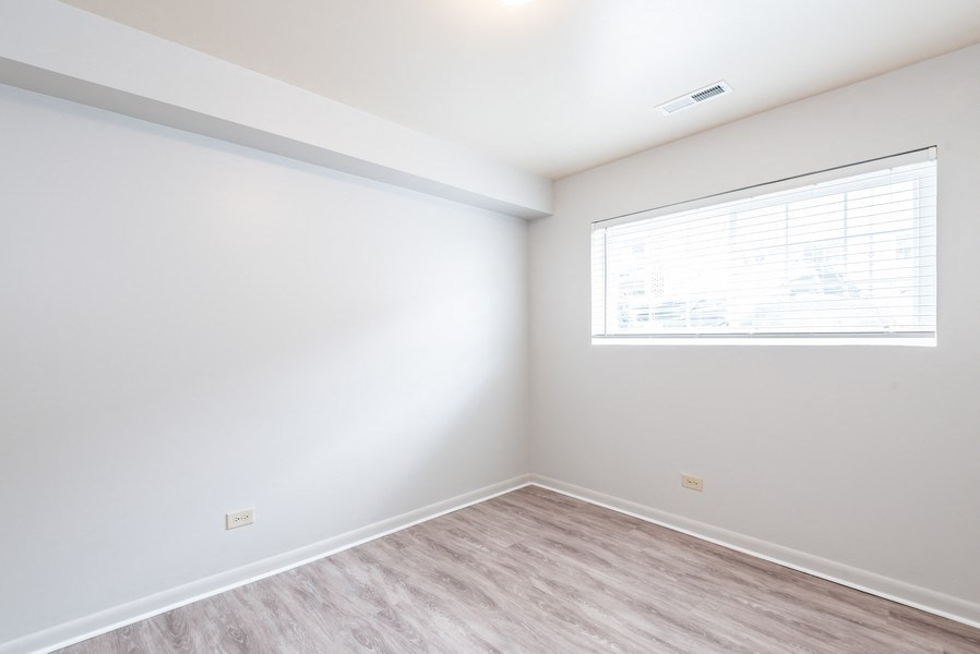 A room with a window and wooden flooring.