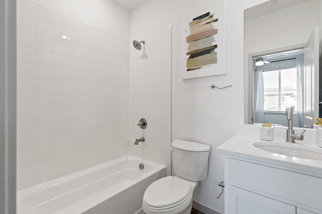 a white bathroom with a tub and a toilet and a sink