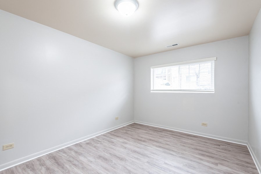 A room with a window and a wooden floor.