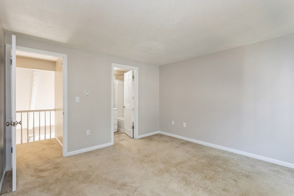 an empty living room with a door to hallway and closet