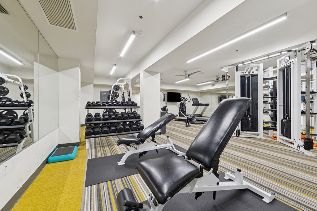 A gym with a variety of equipment including weights and machines.