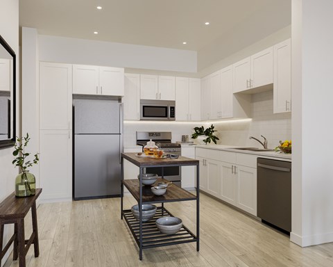 a kitchen with white cabinets and stainless steel appliances and a center island