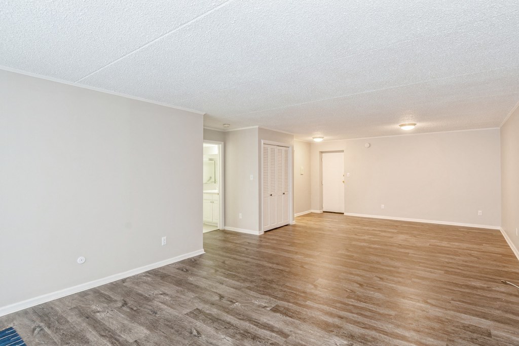 A room with wooden flooring and white walls.