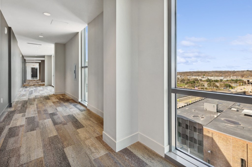 a long hallway with large windows and a view of a city at The Rowe, Michigan