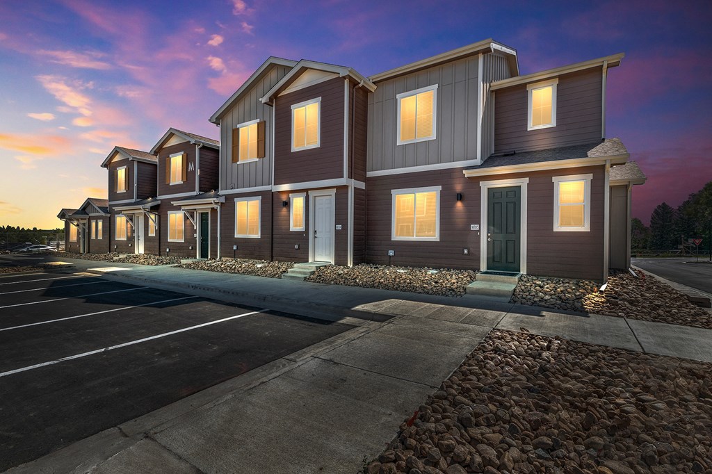 a row of houses with lights on at dusk