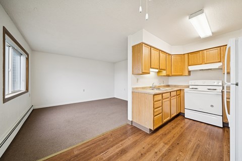 A kitchen with wooden cabinets and a white fridge.