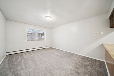 A room with a carpeted floor and a picture on the wall.