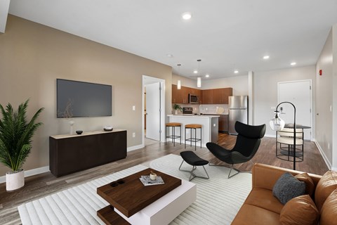 A modern living room with a brown sofa, a wooden coffee table, and a flat-screen TV mounted on the wall.