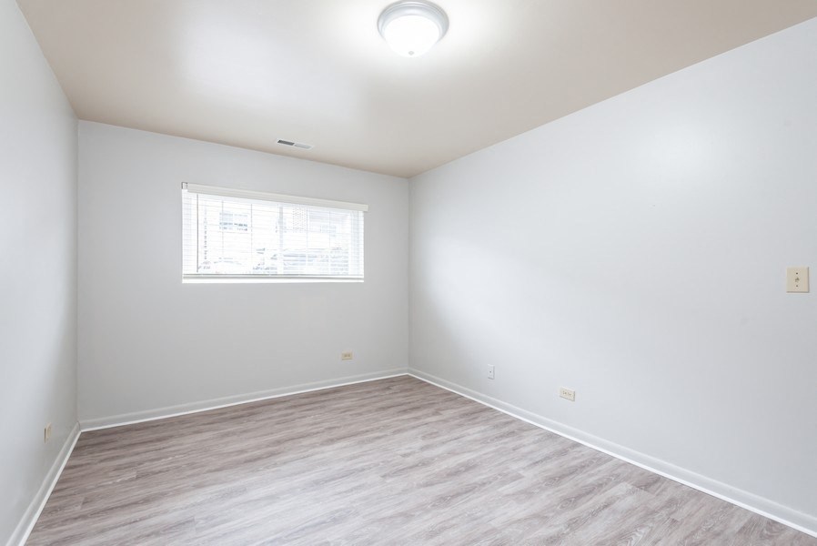 A room with a window and wooden flooring.