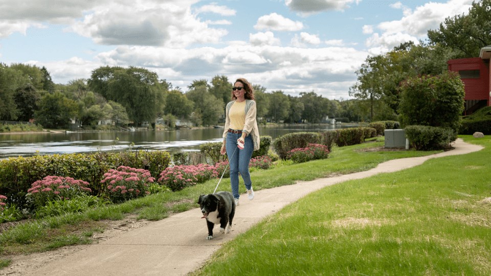 a woman walking her dog in a park at The View Apartments St Charles, Illinois