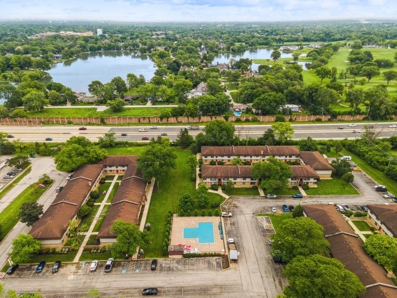 an aerial view of a yard with houses and a lake