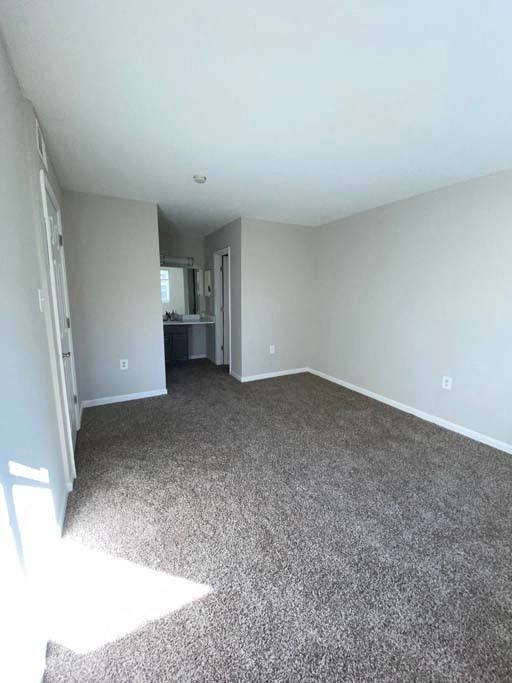 a room with a carpeted floor and a kitchen in the background at ReNew Odenton, Odenton, Maryland