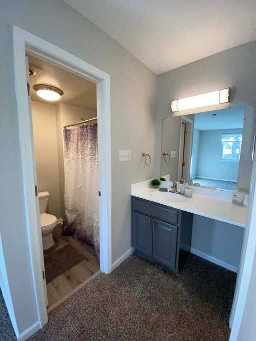 a bathroom with a toilet a sink and a mirror at ReNew Odenton, Odenton, Maryland