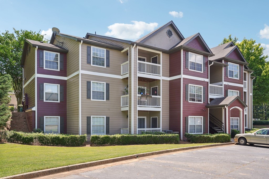 A large apartment building with a car parked in front.