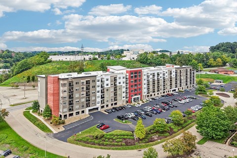 A large apartment complex with a parking lot in front.