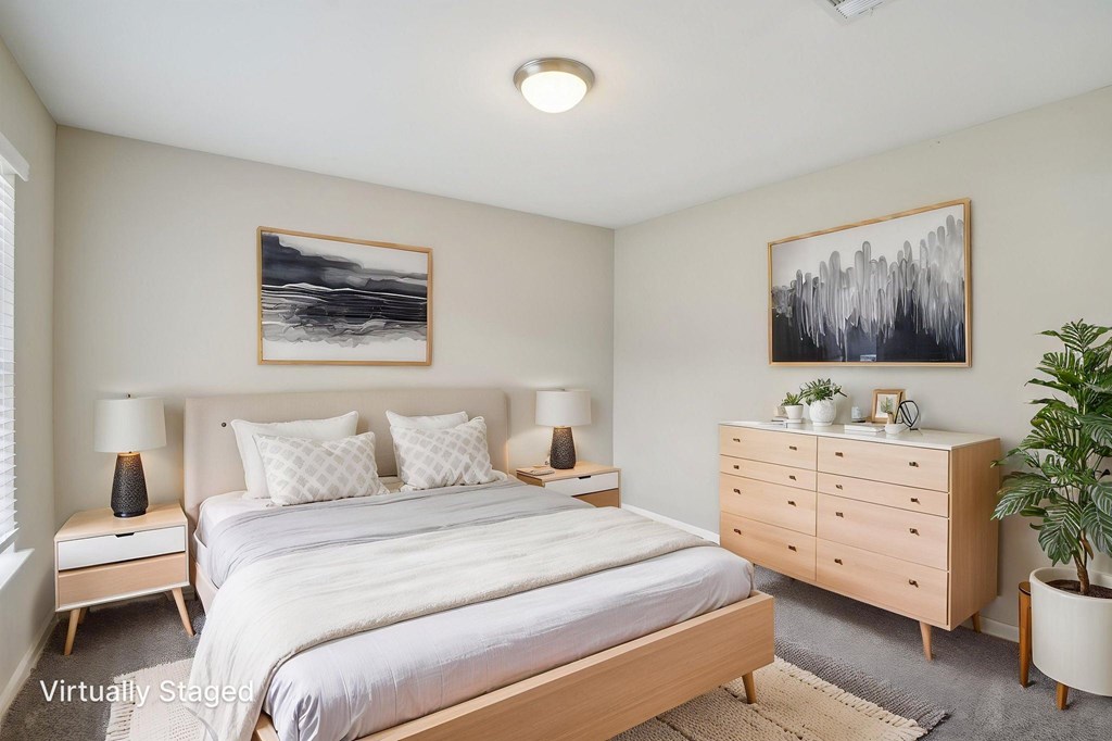 A bedroom with a bed, nightstands, and a dresser.