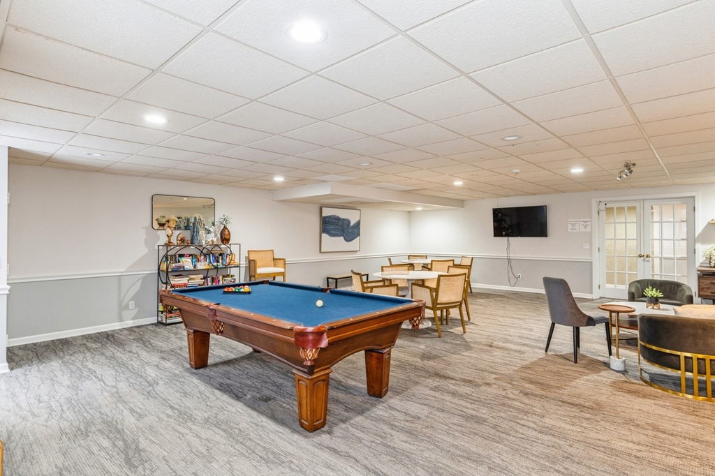A room with a pool table and a TV.