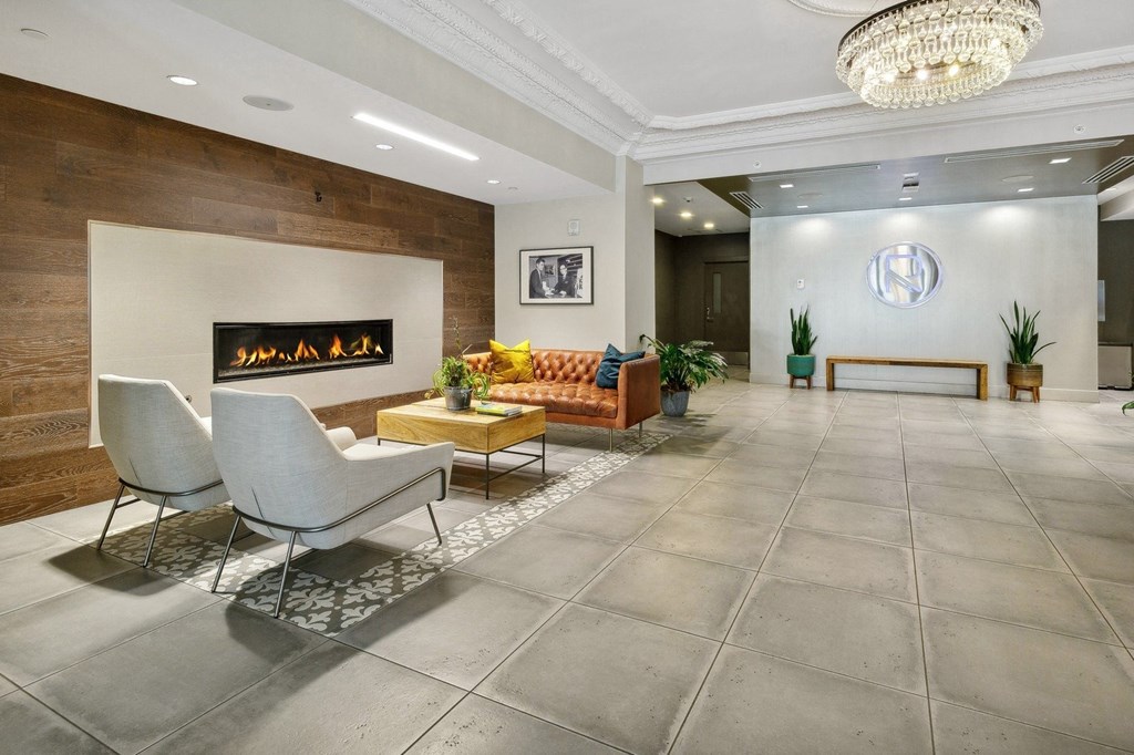 a living room with a couch and chairs in front of a fireplace at The Rowe, Grand Rapids, 49503