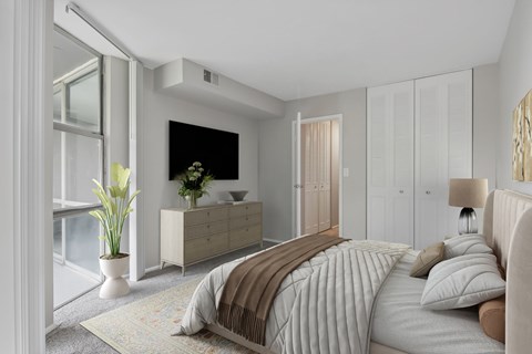 A bedroom with a large bed and a dresser with a plant on top.