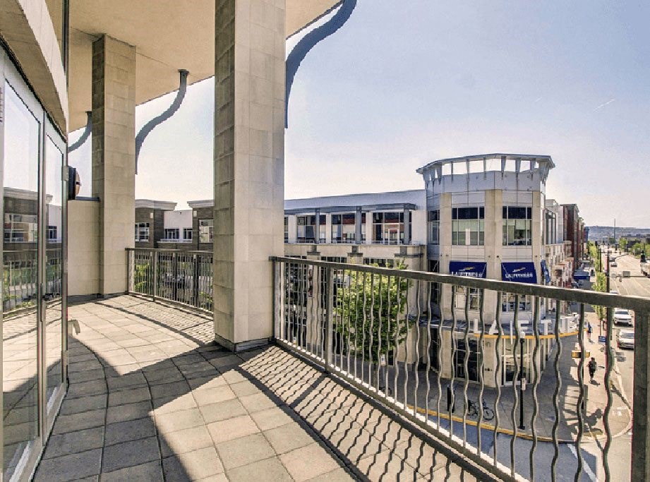a balcony with a black railing and a building in the background  at Flats at Southside, Pittsburgh, 15203