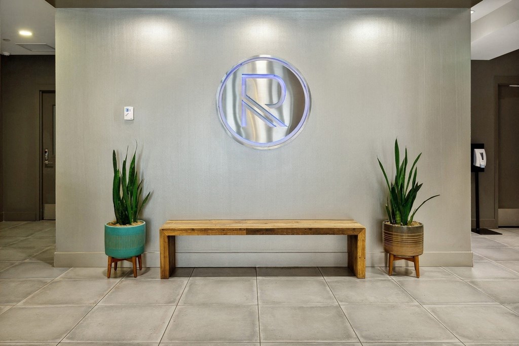 a wall with a bench and plants in a lobby at The Rowe, Grand Rapids, MI