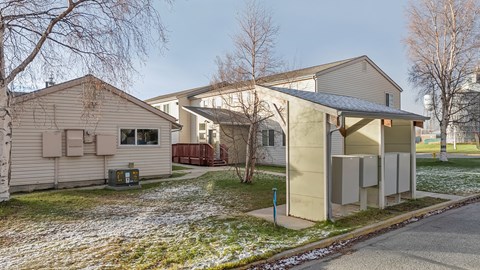 A house with a grey roof and a white fence.