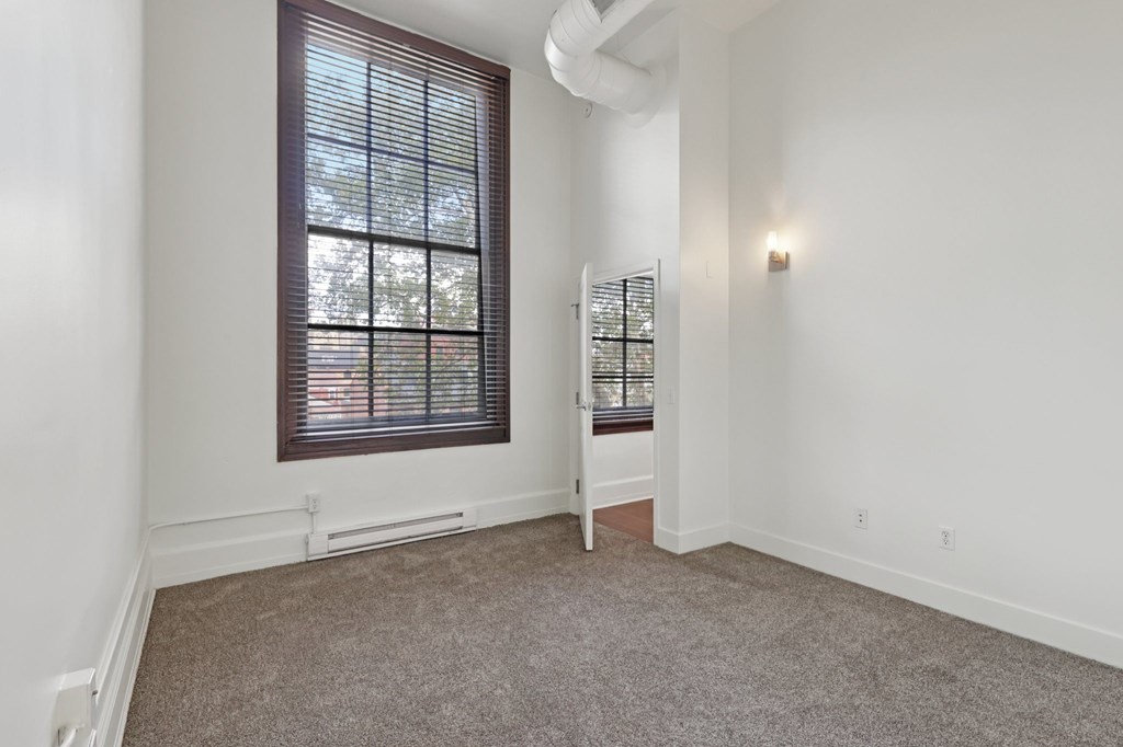 A room with a window and a chair.