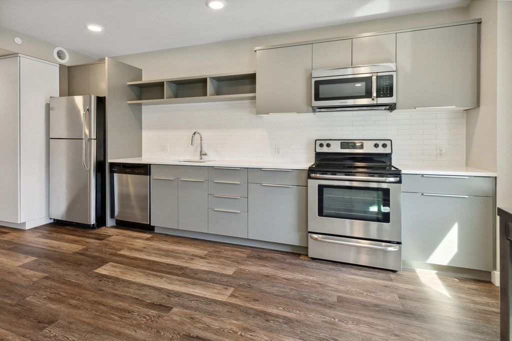 a kitchen with white cabinets and stainless steel appliances at The Rowe, Grand Rapids