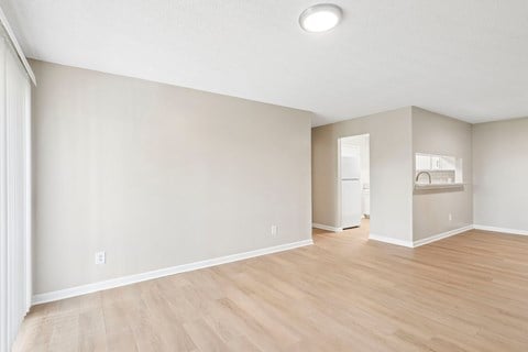 A room with light wood flooring and white walls.