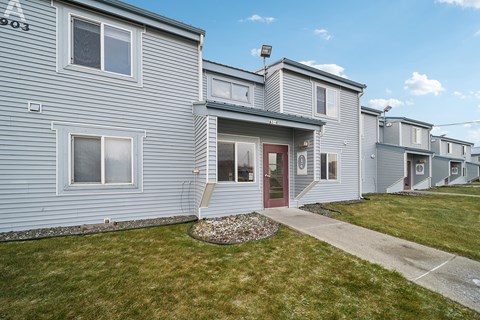 A row of houses with a red door in the middle.