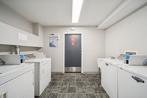 A clean, white-walled kitchen with a stainless steel refrigerator and a tiled floor.