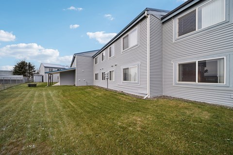 A row of houses with a green lawn in front.