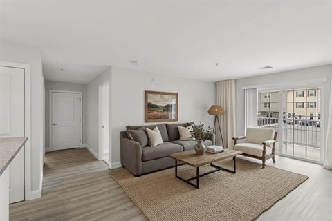 A living room with a grey couch, a coffee table, and a painting on the wall.