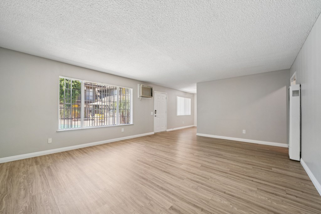 A living room with wooden floors and windows