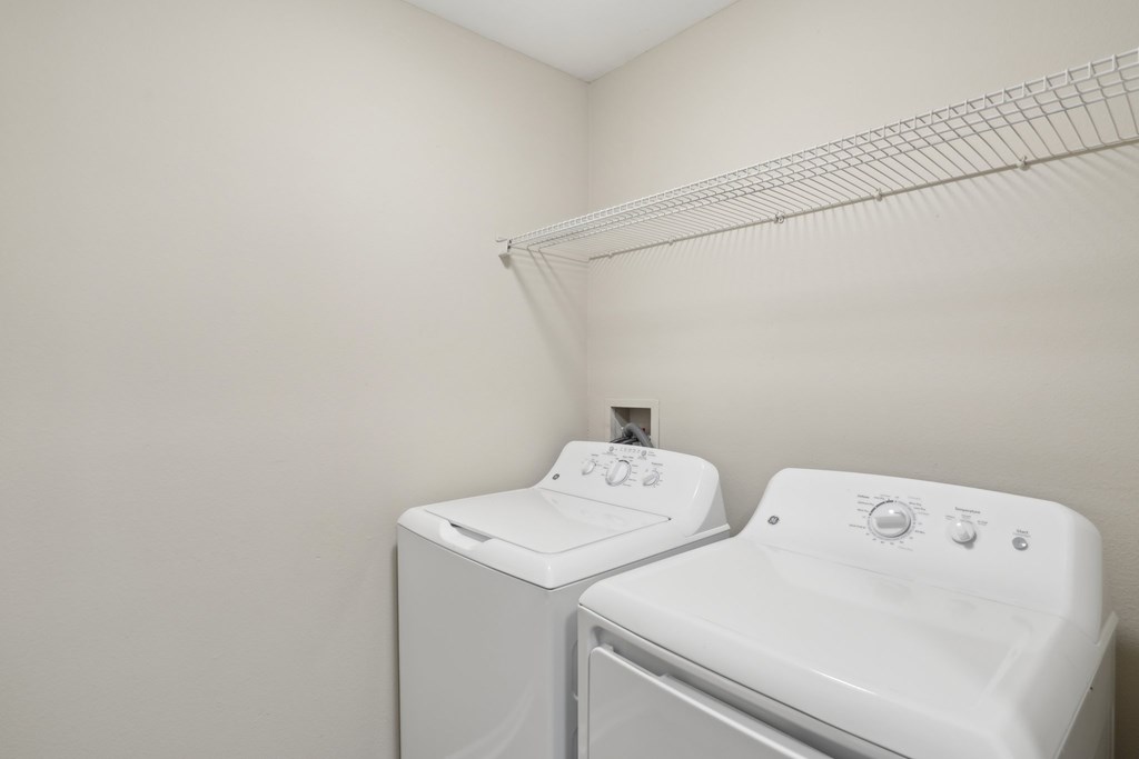 A white washing machine and dryer in a laundry room.
