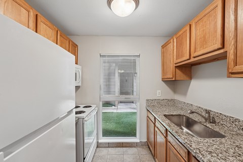 A kitchen with white appliances and wooden cabinets.